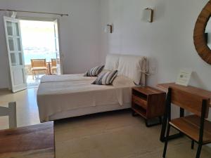 a bedroom with a bed and a table at Panthea Residence in Agios Ioannis Mykonos