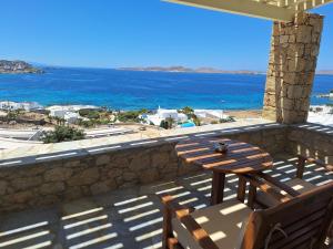 a balcony with a table and chairs and the ocean at Panthea Residence in Agios Ioannis Mykonos +26 photos
