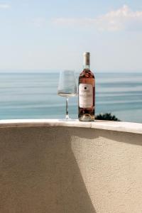 a bottle of wine sitting on a ledge with a wine glass at La Brise Luxury Suites in Nea Peramos