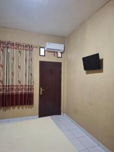 a room with a door and a television on the wall at Penginapan 369 in Sentani