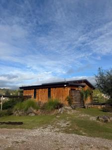 a wooden cabin in a field with a sky at Cabañas colibrí in Villa Carlos Paz
