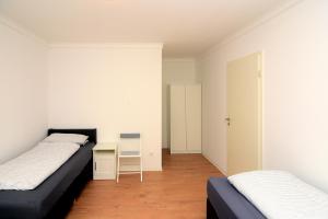 a bedroom with two beds and a desk in it at Brunnenhof - Serviced Apartments in Bekond