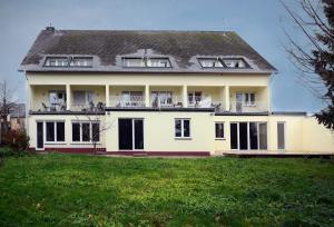 a large white house with a large yard at Brunnenhof - Serviced Apartments in Bekond