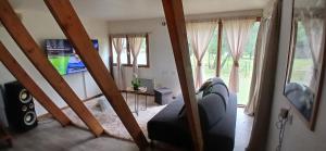a living room with a couch and some windows at Mon petit chalet in Puycornet