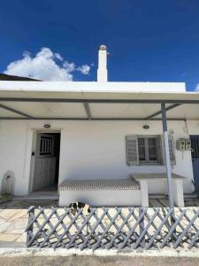 a white house with a bench in front of it at Ormos Isternia House in Istérnia
