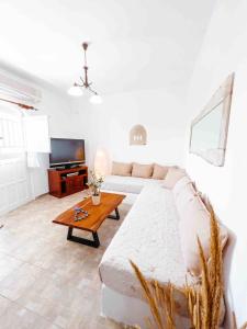 a living room with a white couch and a table at Ormos Isternia House in Istérnia
