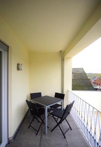 a table and chairs sitting on a balcony at Brunnenhof - Serviced Apartments in Bekond