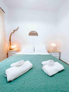a bedroom with a bed with two towels on it at Ormos Isternia House in Istérnia