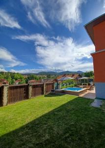 a yard with a fence and a swimming pool at Hedgehog Villa - Вила Таралеж in Velingrad