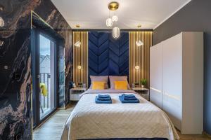 a bedroom with a large bed with blue pillows on it at Golden Eagle Luxury Apartment - Granary Island- Gdańsk Old Town in Gdańsk