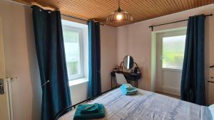 a bedroom with a bed and two windows at Mon Refuge B&B in Jougne
