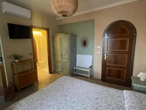 a bedroom with a bed and a cabinet and a television at LaTorrettaLoano Affittacamere in Loano