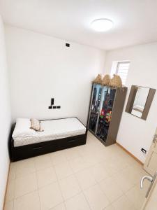 a white room with a bed and a refrigerator at Casa sole Sicilia in Alcamo