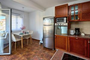 a kitchen with a stainless steel refrigerator and a table at LUNA lux in Đenovići