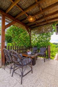 a patio with a table and chairs under a wooden roof at Kuca za odmor Vinica breg in Varaždin +11 photos
