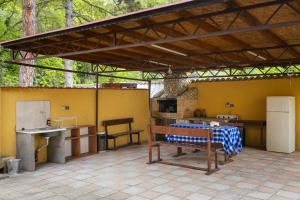 an outdoor kitchen with a table and a bench at Къща за гости Калабрия in Golden Sands