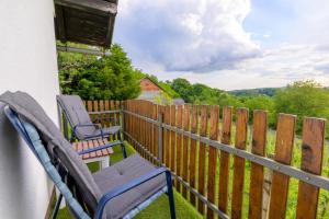 a balcony with two chairs and a fence at Kuca za odmor Vinica breg in Varaždin