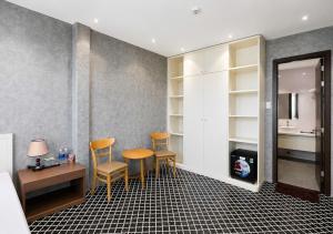 a room with three chairs and a table and a mirror at VMona Hotel in Thôn Kim Long (1)