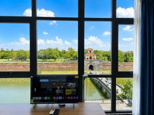 a room with a window with a view of a bridge at VMona Hotel in Thôn Kim Long (1)