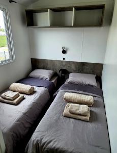 two beds in a small room with towels on them at Moon Lodge in Koksijde