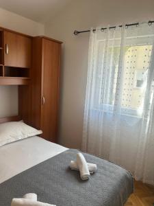 a bedroom with a bed and a window with white curtains at M5 in Promajna