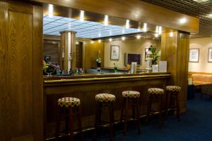 a bar with stools in front of a mirror at VIP Inn Berna Hotel in Lisbon