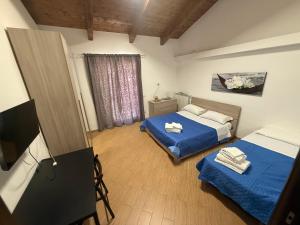 a room with two beds and a tv in it at La Tenuta Michele in Naples