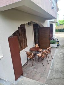 a patio with a table and chairs in a building at Apartman Angela in Igalo +2 photos