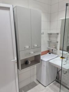 a white bathroom with a sink and a mirror at Apartman Angela in Igalo