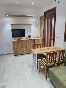 a living room with a table and chairs and a tv at Apartman Angela in Igalo