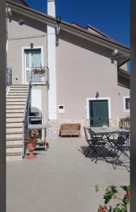 a patio of a white house with a table and chairs at Il Rifugio nelle Stelle in Agerola