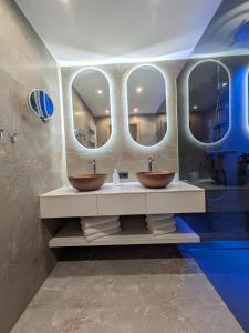 two sinks in a bathroom with two mirrors at Garni Nill in Schwendau