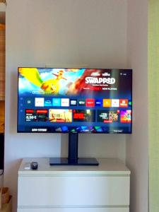 a flat screen tv sitting on top of a white cabinet at Agave by Aloe Residence Possidi in Possidi