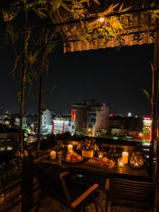 a table with food and candles on a balcony at night at Spring Home 2 in Can Tho