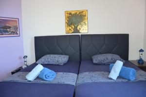 a bedroom with a bed with blue pillows on it at Sunray Room for Two in Zagora in Zagora