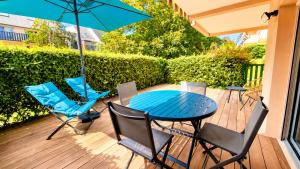a patio with a table and chairs and an umbrella at HOME ET HOLIDAY Le Chardonnay in La Baule