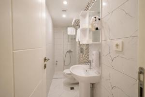 a white bathroom with a sink and a toilet at Deniz Boutique Hotel in Antalya +45 photos