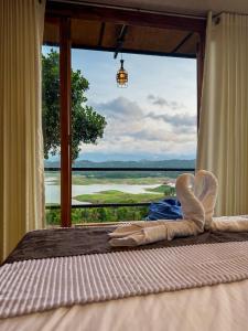 a bed in a room with a large window at Victoria Sky Crest - Kandy in Teldeniya