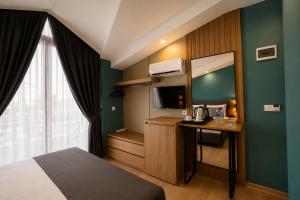 a room with a bed and a desk with a microwave at Deniz Boutique Hotel in Antalya