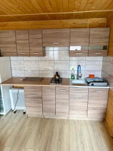 a kitchen with wooden cabinets and a sink at Gościniec u Dzięcioła in Milonki +9 photos