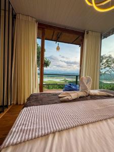 a bedroom with a large bed with a large window at Victoria Sky Crest - Kandy in Teldeniya