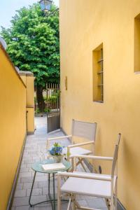 a patio with two chairs and a table with flowers at The Crystal Vine Lounge in Montecarlo