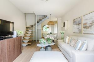 a living room with a white couch and a staircase at The Crystal Vine Lounge in Montecarlo