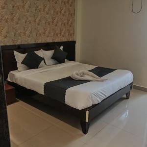 a bed with a black and white comforter and pillows at Udupi Grand Lodging and Boarding in Chākan