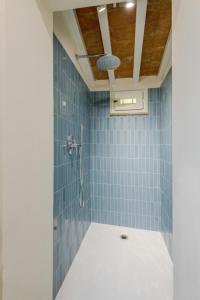 a bathroom with a shower with blue tiles at The Crystal Vine Lounge in Montecarlo +35 photos