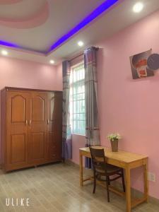 a dining room with a wooden table and a window at Thuy's homestay in Vung Tau