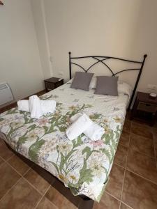 a bed with a floral bedspread and pillows on it at Mirador de los Tejados in Alcalá del Júcar