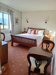 a bedroom with a large bed and a table at Corthna Lodge in Schull