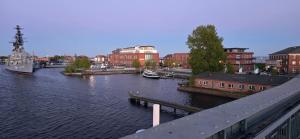 a river with boats in a city with buildings at Sonnige Ferienzimmer WHV in Wilhelmshaven