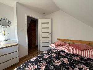 a bedroom with a bed and a dresser at Domek Matyjówka in Ustrzyki Dolne
